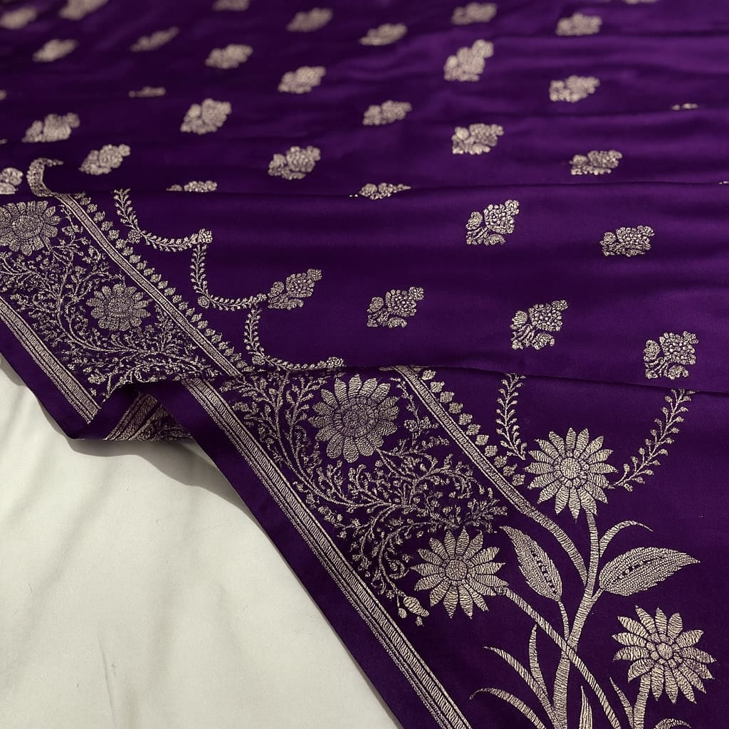 Purple fabric with silver floral patterns on a white background