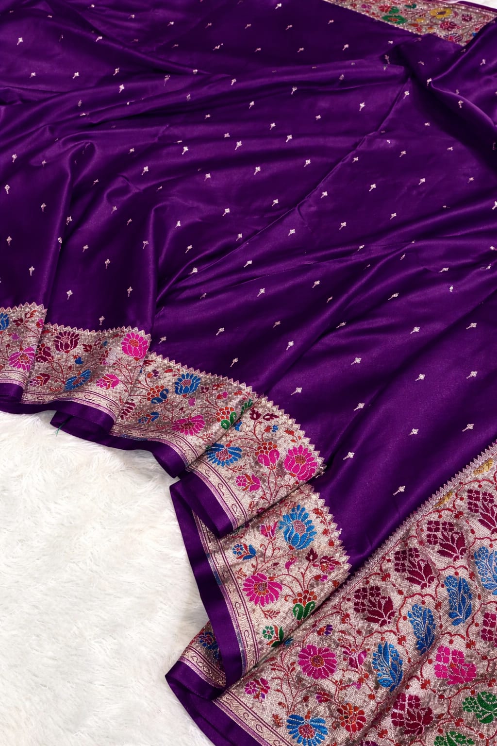 Purple saree with intricate floral patterns on a white background