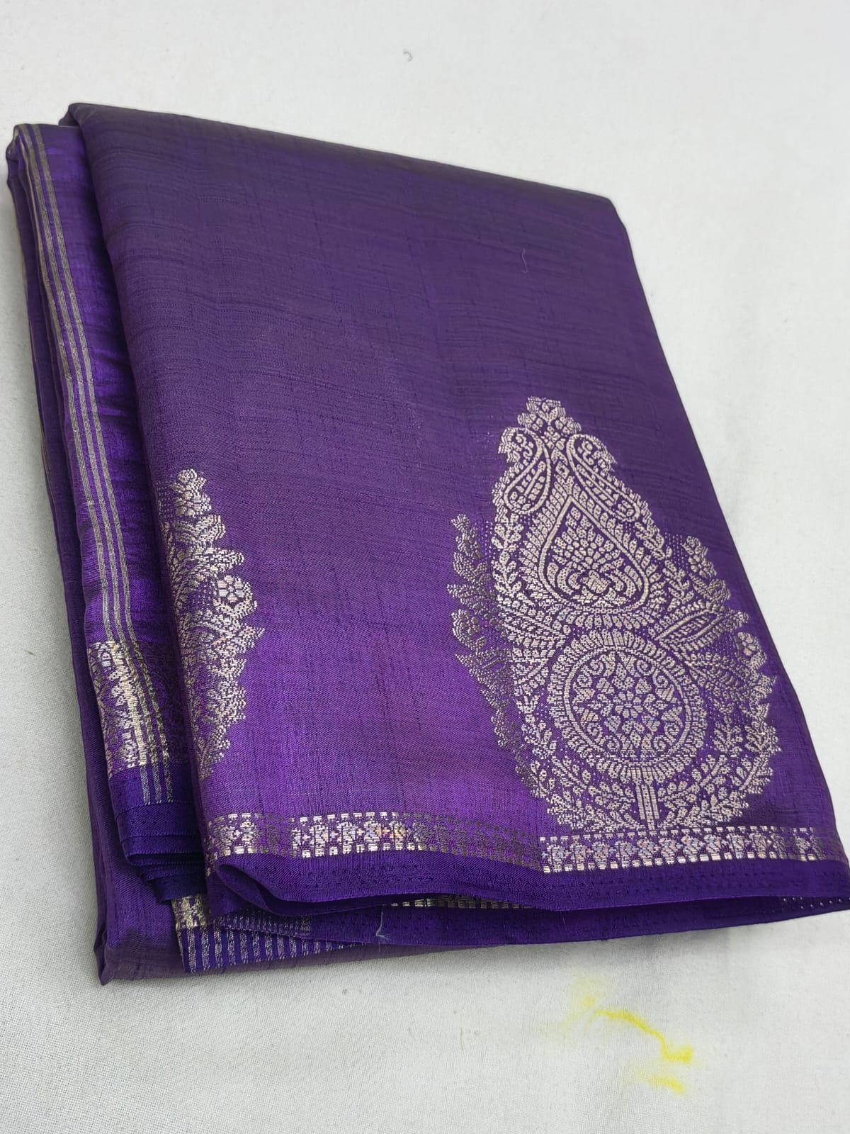 Purple fabric with white embroidery on a white background