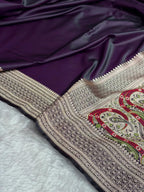Embroidered fabric with intricate patterns on a purple and white background
