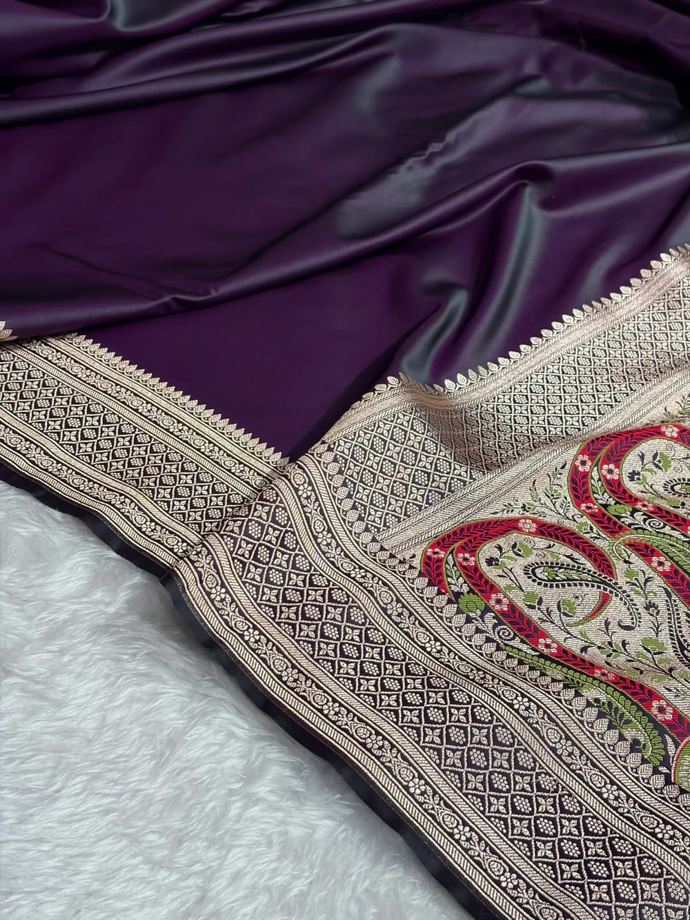 Embroidered fabric with intricate patterns on a purple and white background