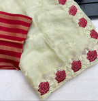 White fabric with red floral embroidery on a black surface