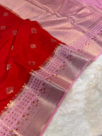 Red fabric with gold embroidery on a pink and white checkered background