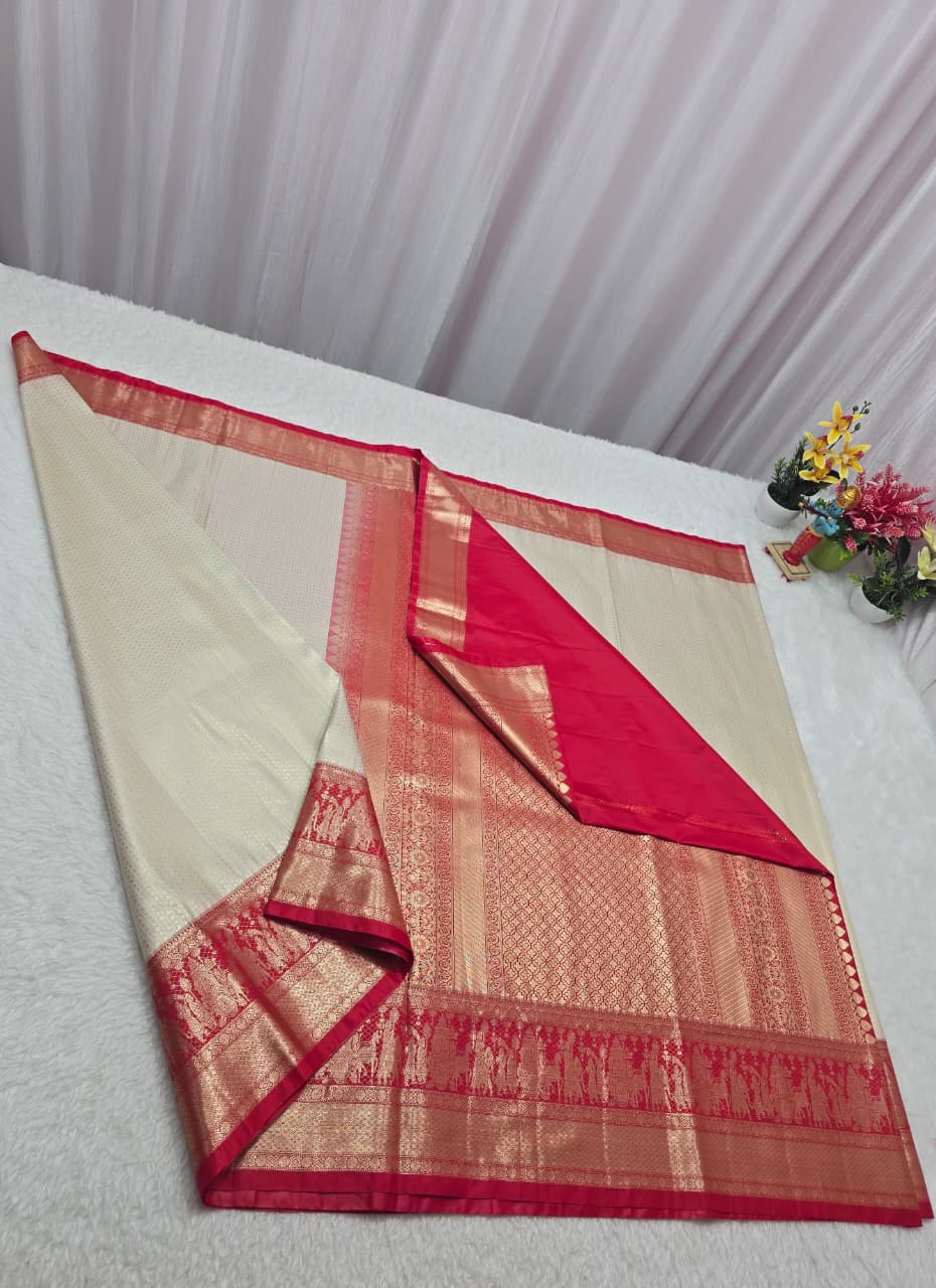 Red and beige saree with floral decoration on a white surface