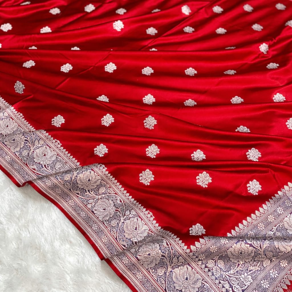 Red fabric with white floral patterns and a detailed border on a white background