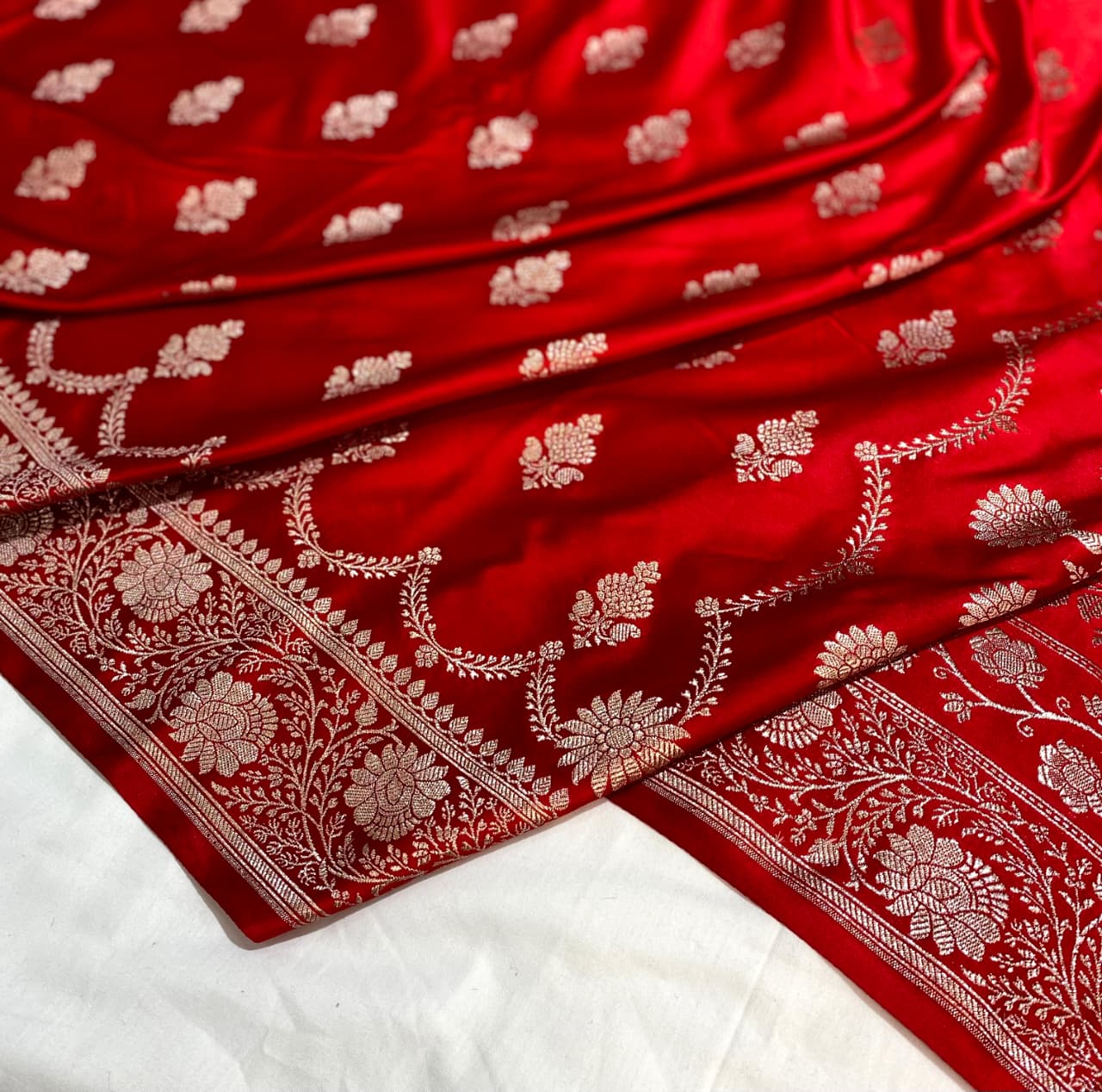 Red fabric with white floral patterns on a white background