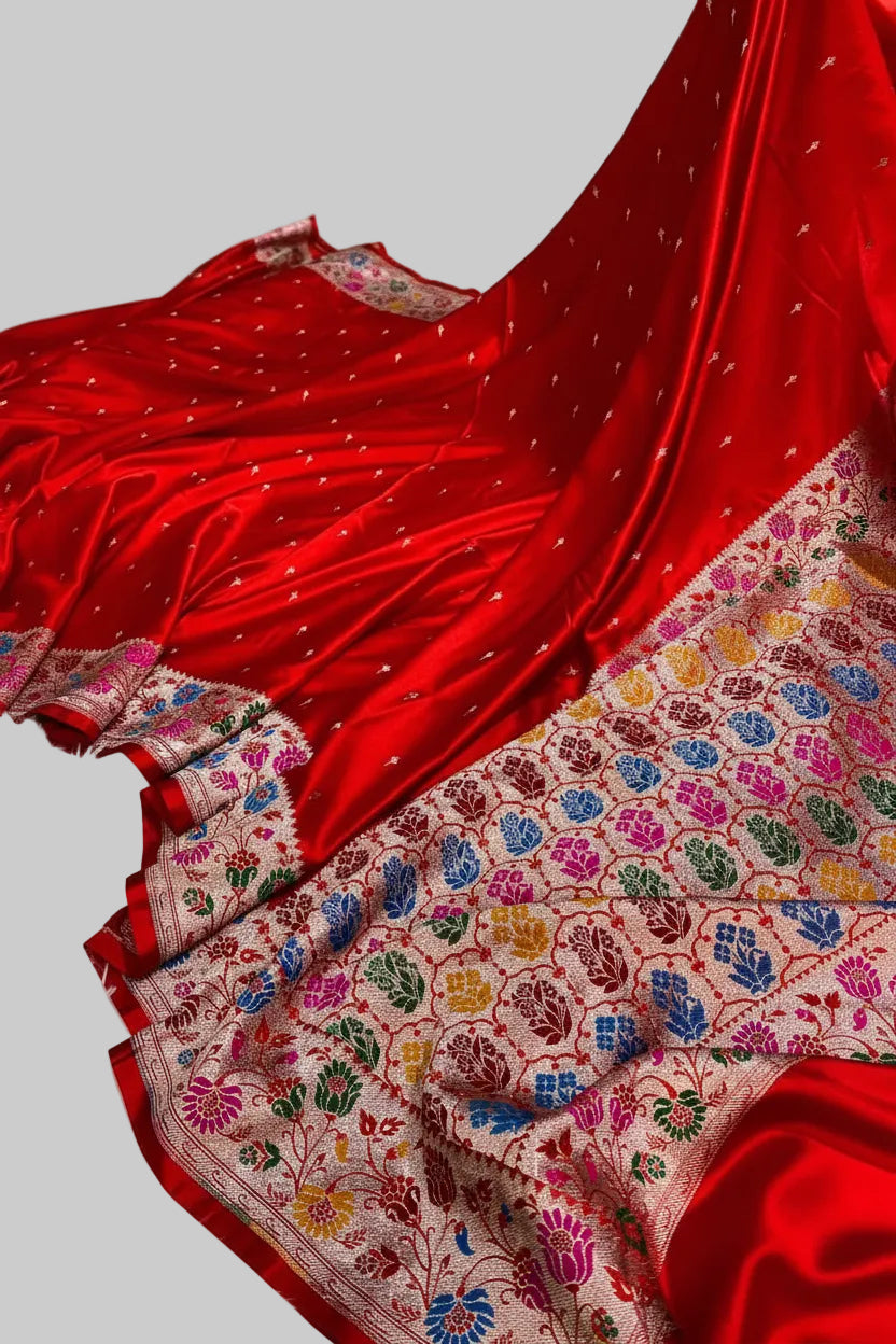Red saree with a colorful pattern on a white surface