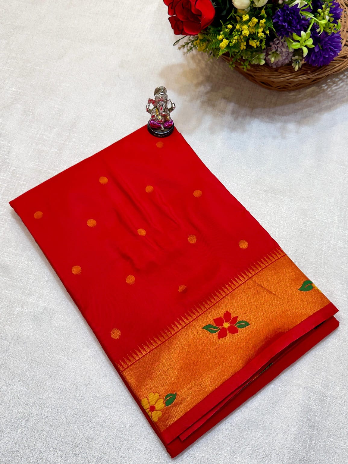 Red and orange saree with floral patterns on a white background