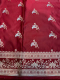 Red fabric with white floral patterns and intricate border