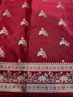 Red fabric with white floral patterns and intricate border
