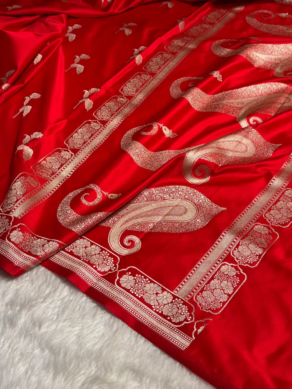 Red fabric with intricate white patterns on a white background