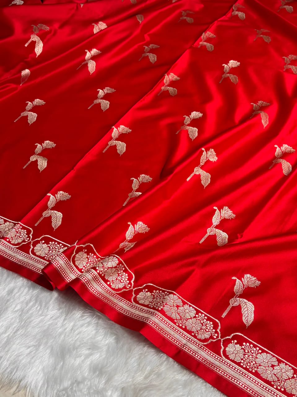 Red fabric with white floral embroidery on a white background