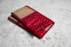 Red fabric with gold patterns in front of a Zaira box on a white background