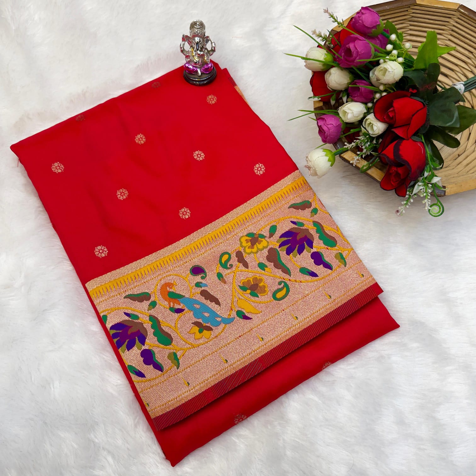 Red saree with floral patterns on a white background
