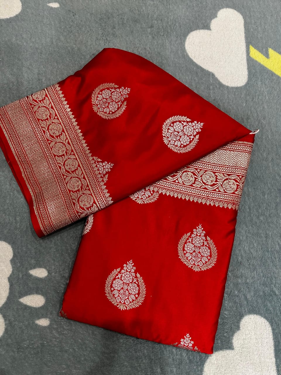 Red fabric with white patterns on a gray surface