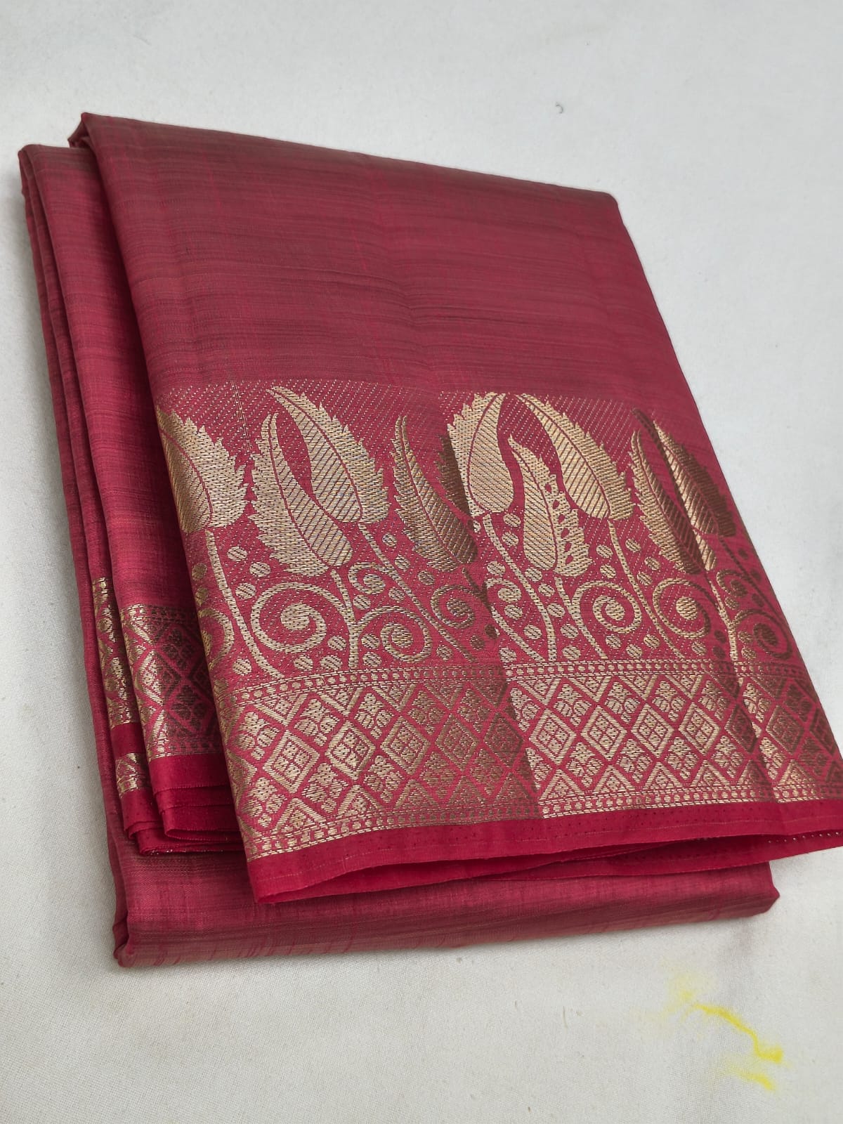 Maroon saree with gold patterns on a white background