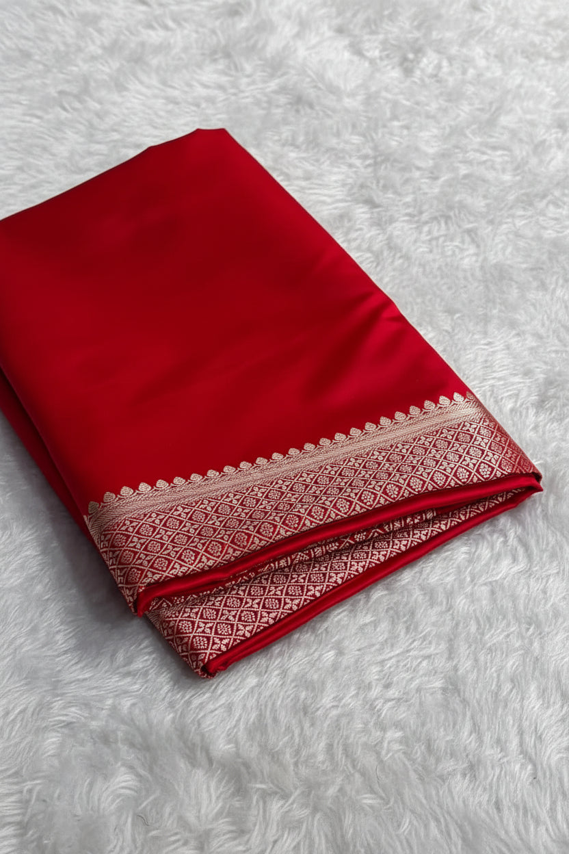 Red fabric with a patterned border on a white surface
