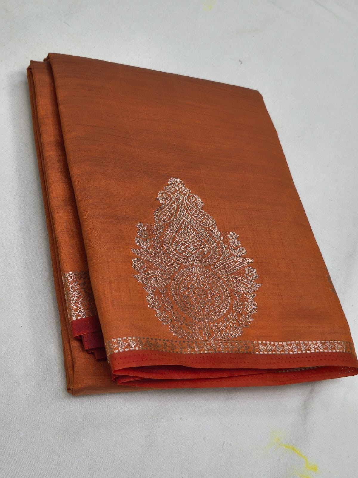 Brown saree with silver embroidery on a white background