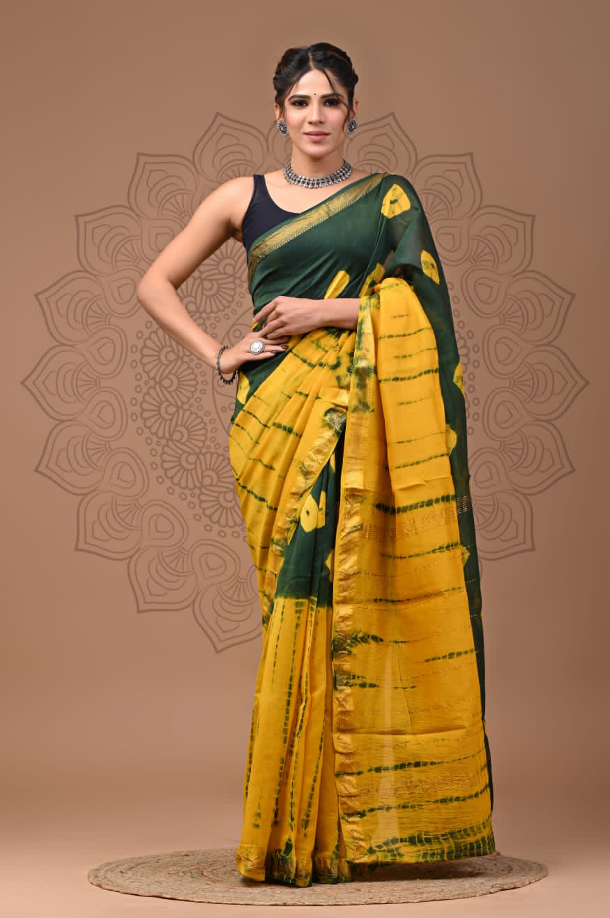 Woman wearing a green and yellow saree with a decorative background
