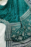Teal saree with white patterns on a textured surface