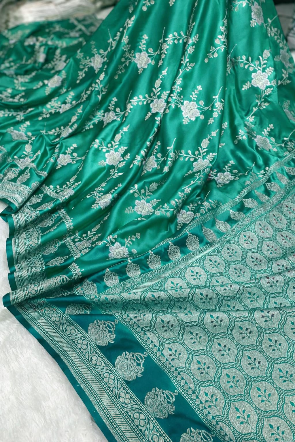 Green fabric with white floral patterns on a white background