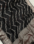 Black fabric with intricate silver embroidery on a white background