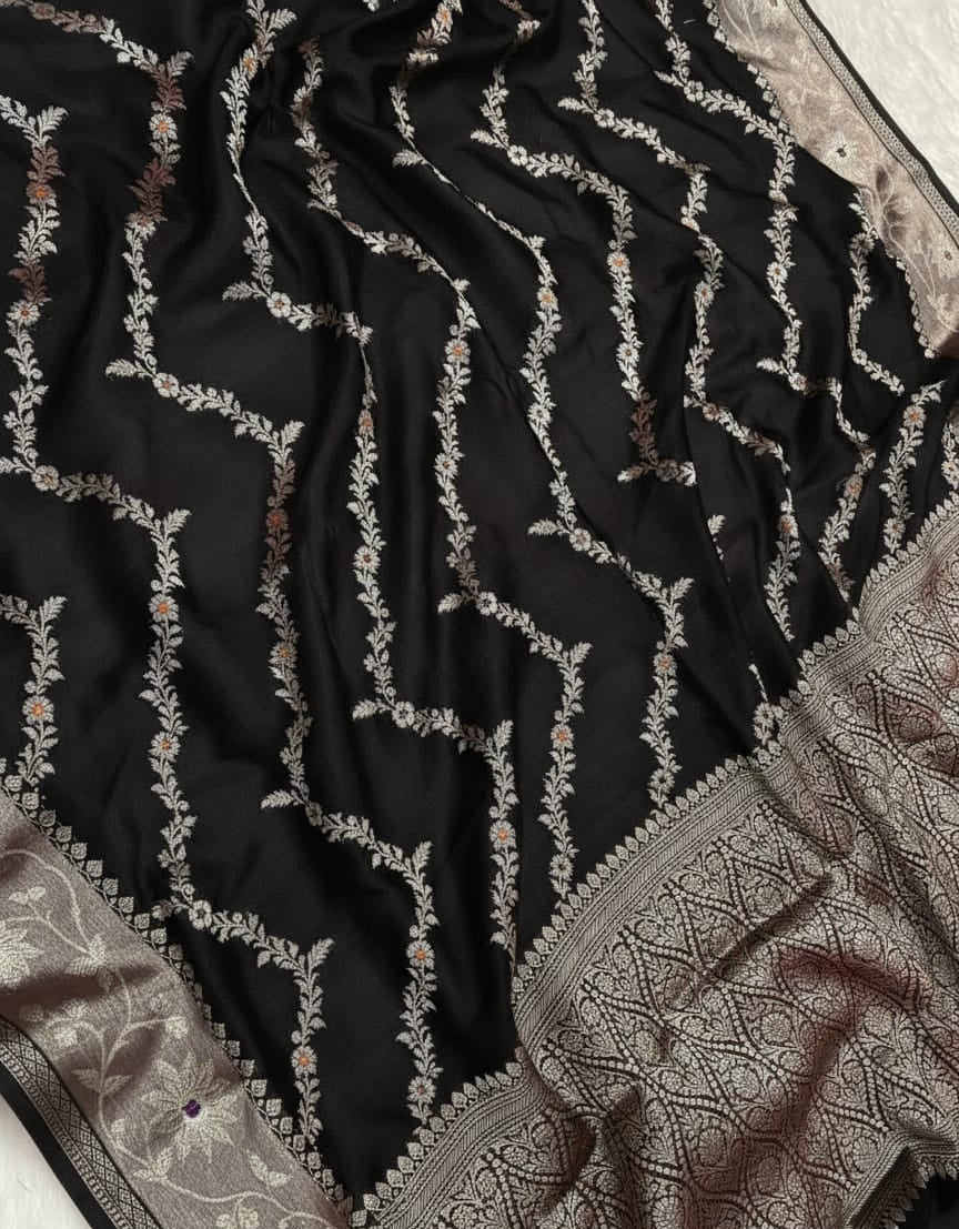 Black fabric with intricate silver embroidery on a white background