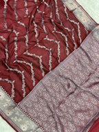 Close-up of a maroon fabric with intricate white patterns