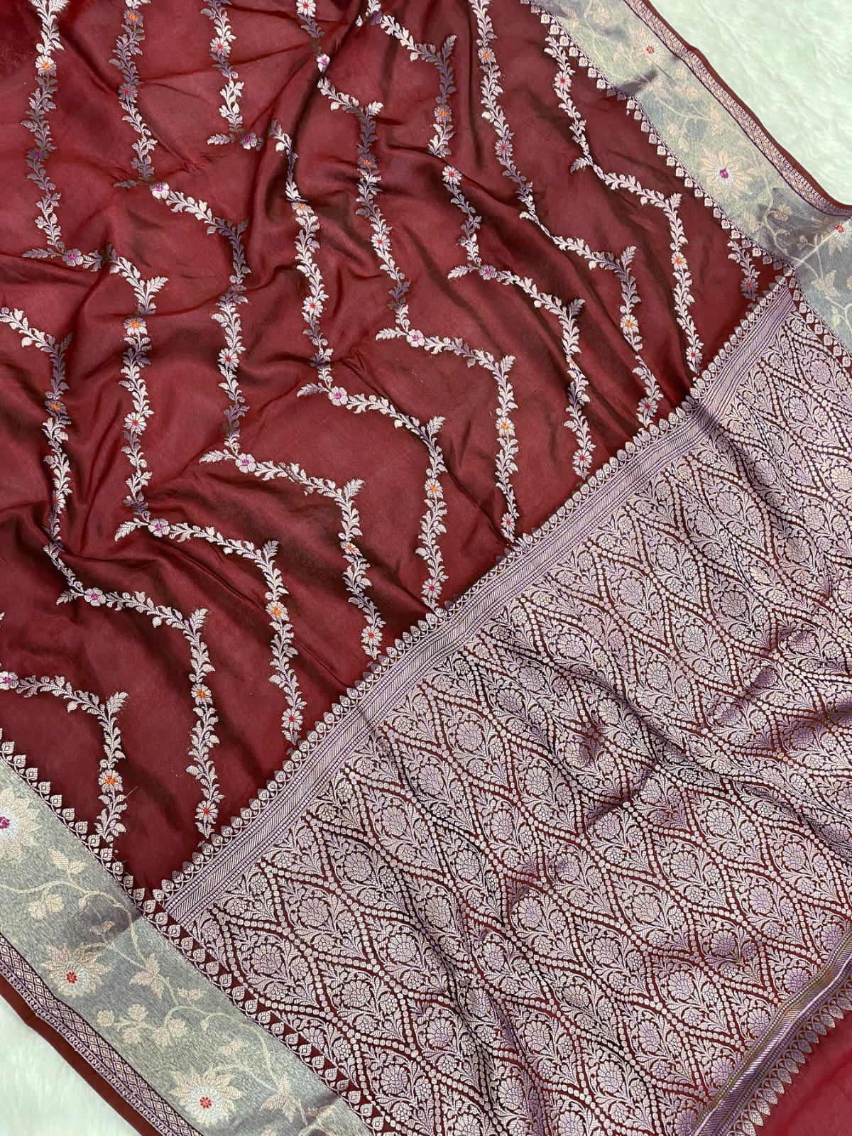 Close-up of a maroon fabric with intricate white patterns