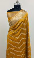 Yellow saree with white lace on a mannequin against a light gray background