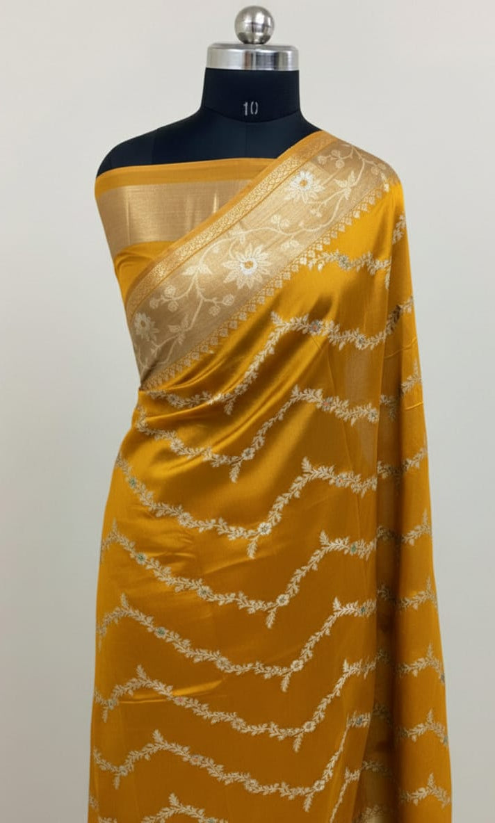 Yellow saree with white lace on a mannequin against a light gray background