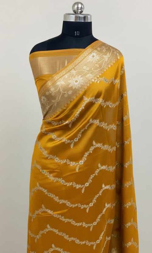 Yellow saree with white lace on a mannequin against a light gray background