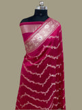 Pink saree with white embroidery on a mannequin against a beige background