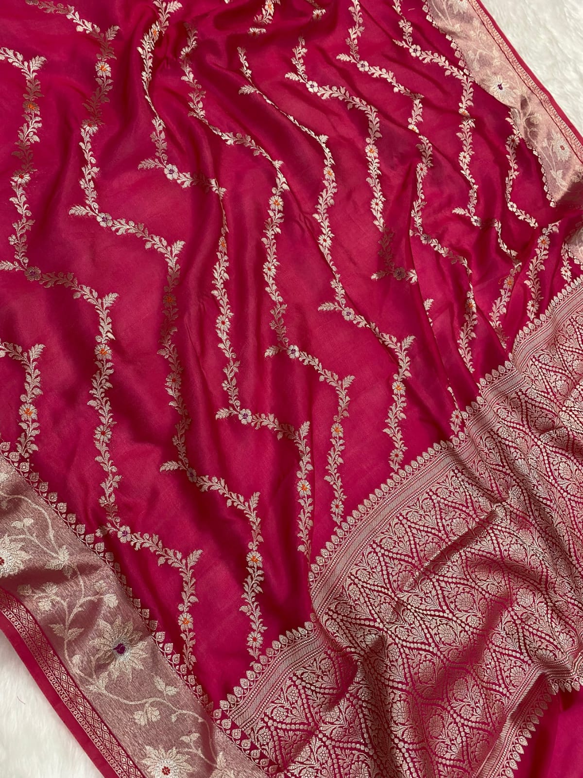 Pink fabric with intricate gold embroidery on a white background