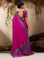 Woman wearing a pink saree with a blue blouse against a neutral background