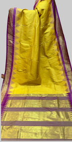 Yellow saree with purple and brown border on a white background