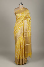 Yellow saree with floral patterns on a dark surface
