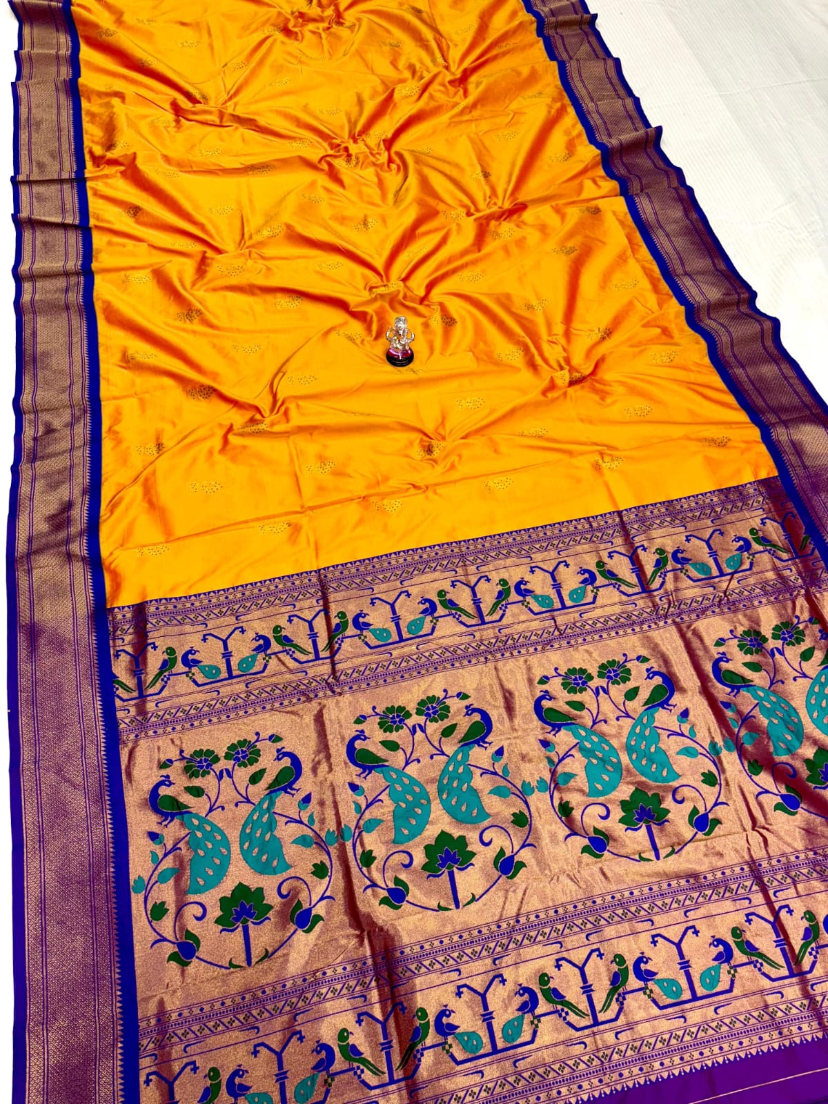 Yellow saree with peacock patterns on a purple background
