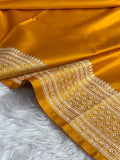 Orange fabric with intricate white patterns on a fluffy white surface