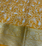 Yellow fabric with white floral patterns on a metallic surface