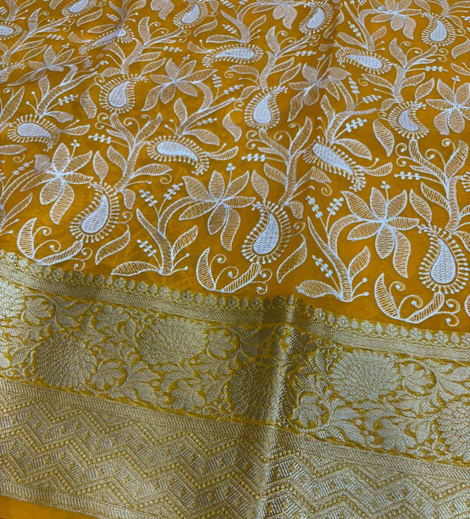 Yellow fabric with white floral patterns on a metallic surface