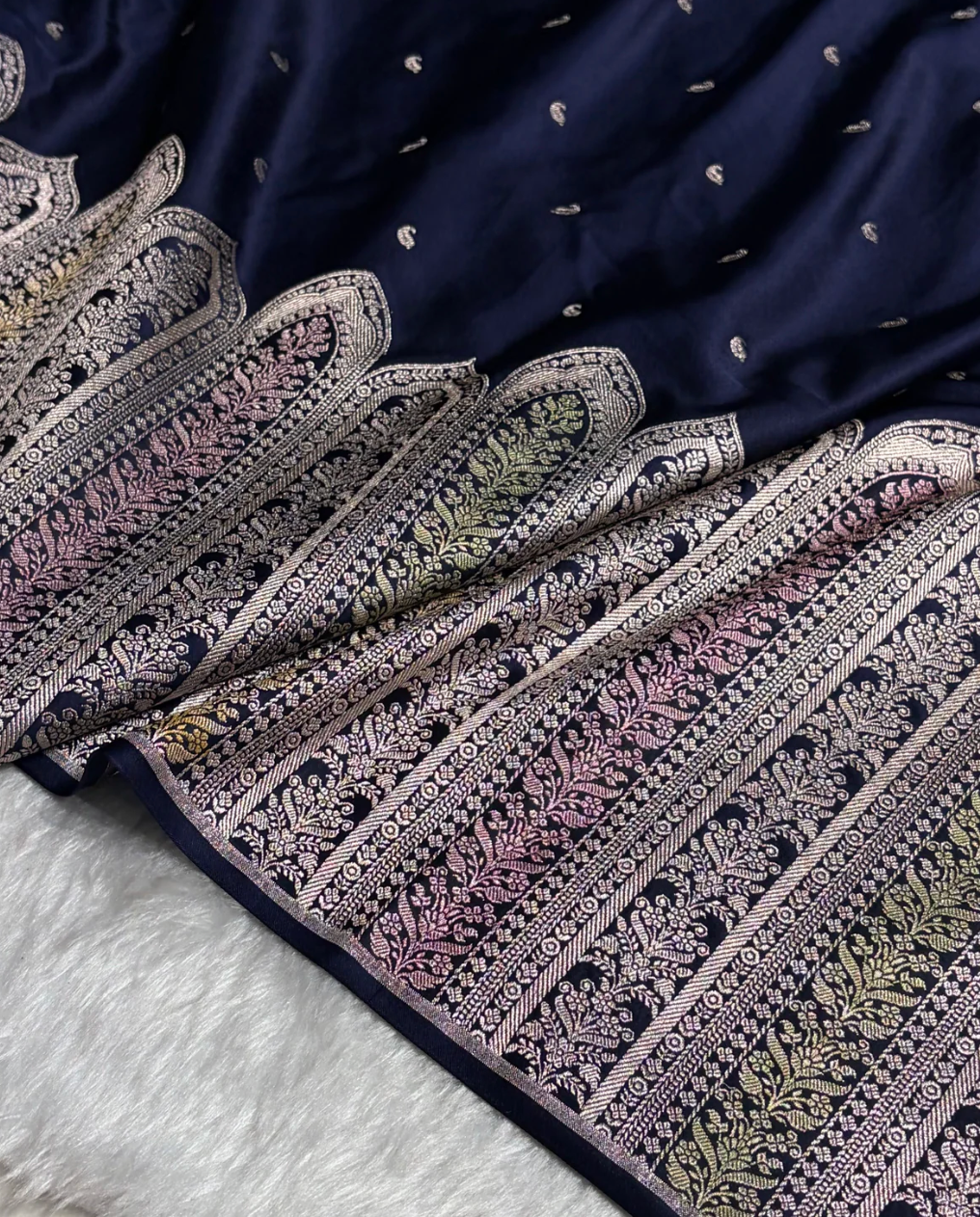 Navy blue fabric with intricate white patterns on a white surface